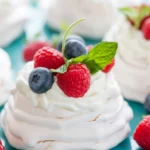 Mini pavlova z kremem i świeżymi owocami na talerzu