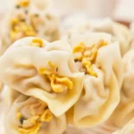 Pierogi z kapustą i grzybami na talerzu z dodatkiem cebuli i przypraw