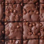 Domowe brownie z chrupiącymi brzegami i fudżowym wnętrzem na talerzu.